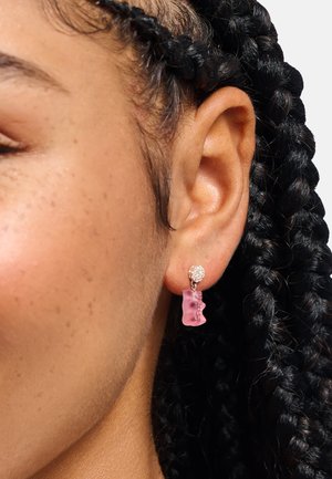 Rosa Gummibärchen-Ohrringe mit funkelndem Steinakzent, glänzender Textur und verspieltem Design, aufgehängt an einem Metallstift.