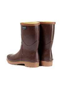 Bruine rubberlaarzen met een gestructureerde afwerking, tan accenten aan de bovenkant, logo aan de achterkant en een gepatternde zool voor grip.
