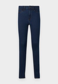Jean skinny bleu foncé avec poches avant, passants pour ceinture et fermeture à boutons sur fond blanc.