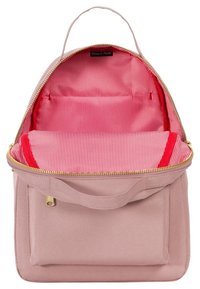 Jasnoróżowy plecak z płótna z złotym zamkiem, czerwonym wnętrzem i paskowym wzorem w środku, z górnym uchwytem i przednią kieszenią.