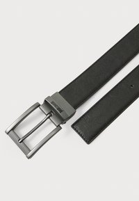 Curea din piele neagră cu o cataramă metalică. Catarama are un finisaj periat și un design cu două pronguri, subliniind durabilitatea și stilul.