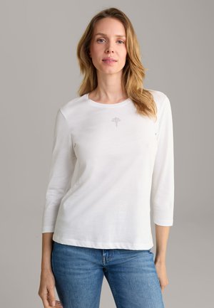 White long-sleeve t-shirt made of soft fabric with a round neckline. Features a small decorative design at the chest and relaxed fit.