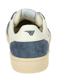Sneaker in navy suede with a white leather heel. Features a padded collar, textured details, and a cream rubber sole.