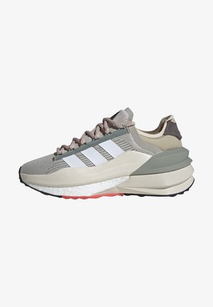 Baskets athlétiques gris clair et beige avec trois bandes blanches, lacets rosés et semelle épaisse et rembourrée avec des accents gris et corail.
