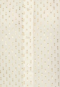 Tissu blanc avec un motif de rectangles métalliques dorés ponctués et des boutons blancs au centre.