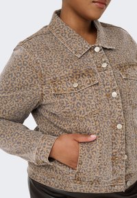 Leoparda raksta denima jaka bēšos un brūnos toņos. Iespējas: divas krūšu kabatas, pogu aizdare un klasiskā apkakle. Strukturēta auduma.