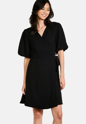 Black wrap dress with short puff sleeves, deep V-neck, and tie detail at the waist, featuring a soft texture and flowing skirt.