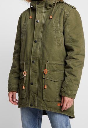 Olivgrüne Parka-Jacke mit durchgehendem Reißverschluss und Druckknopfverschluss, verstellbarer Kapuze mit Kordelzug und mehreren vorderen Taschen mit Knebelverschlussakzenten.