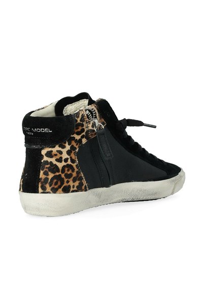 Sneaker alta in pelle nera con accenti in stampa leopardata. Presenta una cerniera laterale, un tessuto strutturato e una suola in gomma bianca usurata.