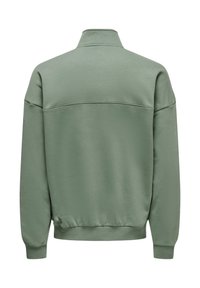 Sweatshirt vert léger avec un col montant, des poignets côtelés et une ceinture ajustée ; présente une texture lisse et un design minimaliste.