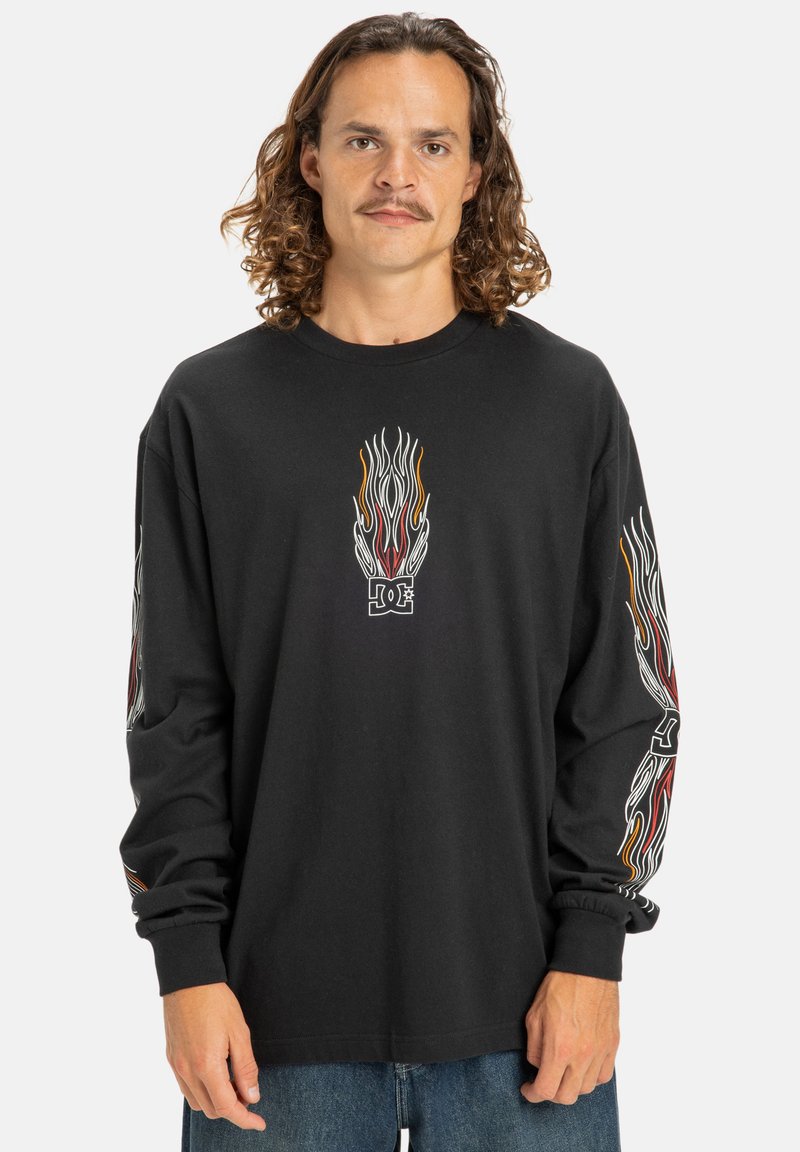 Schwarzes Longsleeve-T-Shirt aus Baumwolle mit Flammengrafiken in Rot, Orange und Weiß auf der Vorderseite und den Ärmeln sowie einem Rundhalsausschnitt.