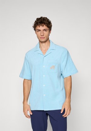 Lyseblå knapp-up skjorte, kort erme, laget av mykt stoff, med lomme med brodert detalj og avslappet passform.
