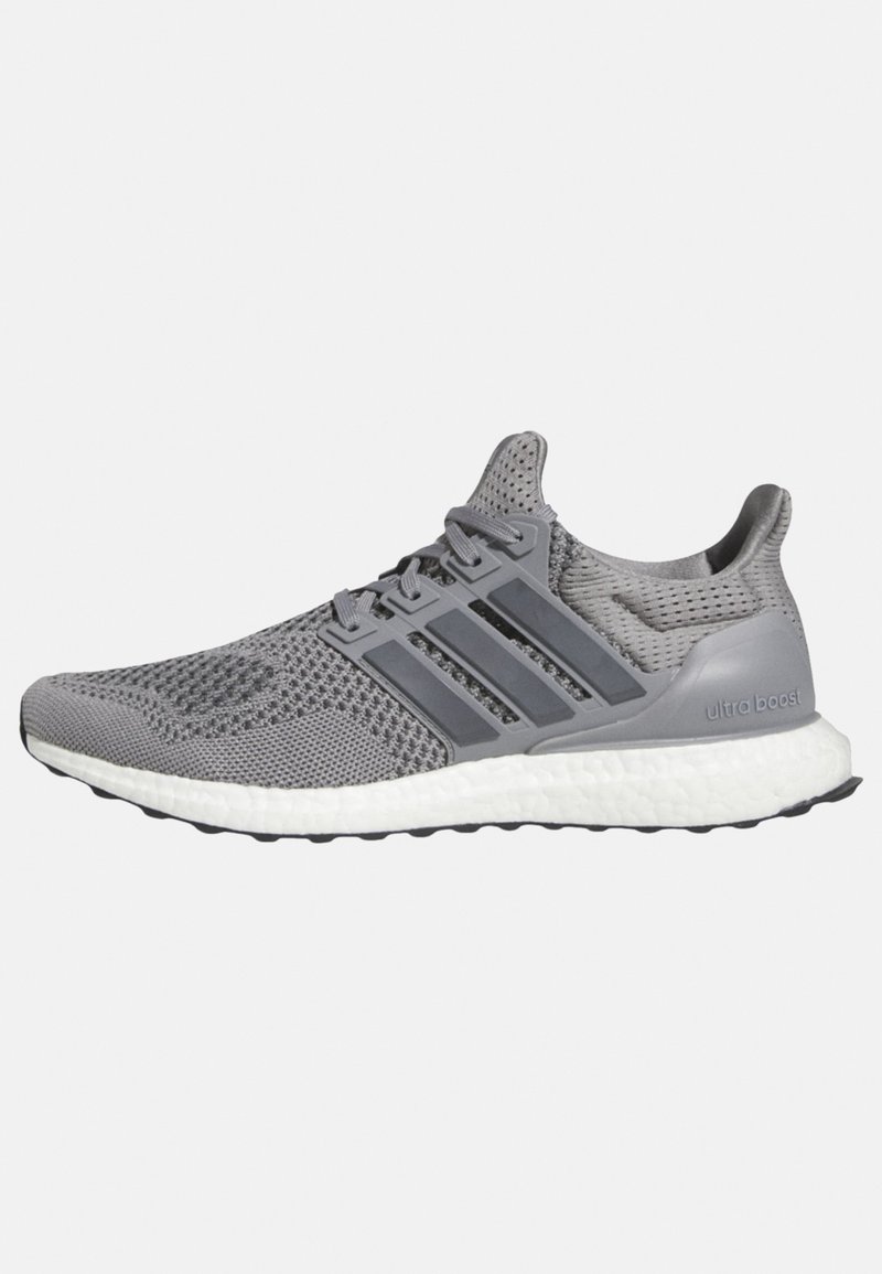 Šedá sportovní bota s prodyšným pleteným svrškem, s třemi pruhy, bílou polstrovanou podrážkou a černou gumovou podešví. Na patě branding "Ultra Boost".