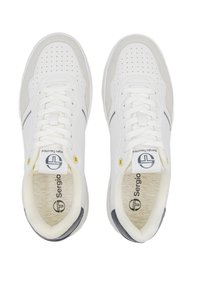 Weiße Sneakers mit durchbrochenem Design, Wildleder-Akzenten und schwarzem Streifen; ausgestattet mit weißen Schnürsenkeln und einem gebrandeten Zungenetikett. Gummisohle.