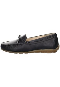 Zapato mocasín de cuero negro con punta redondeada, lazo decorativo en la parte delantera y suela de goma en contraste. Sutiles costuras decorativas a los lados.