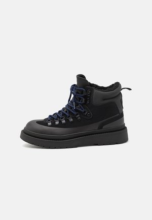 Black hiking boots with blue laces and metal eyelets. Features a textured leather upper, padded collar, and a thick rubber sole for traction.