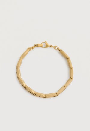 Bracelet doré avec des maillons allongés et polis, fermé par un fermoir mousqueton, sur un fond blanc uni.