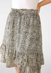 Sort-hvidt blomsterprint nederdel med flæsekant, letvægtsstof, elastisk talje og knælængde.