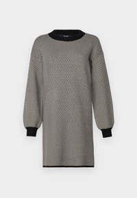 Vestido de malha com um padrão de espinha de peixe preto e branco, gola redonda e mangas longas em balão com punhos canelados, apresentando uma silhueta solta.