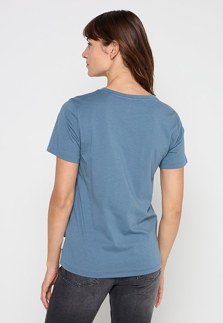 Blaues T-Shirt mit kurzen Ärmeln, runden Halsausschnitt und lockerer Passform. Hergestellt aus weichem, leichtem Stoff. Etikett unten links sichtbar.