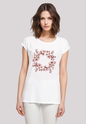 Weißes Baumwoll-T-Shirt mit floralem Druck in Rosa- und Beigetönen, Rundhalsausschnitt und umgeschlagenen kurzen Ärmeln.