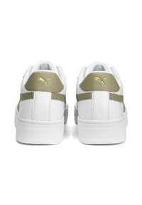 Baskets blanches avec une tige en cuir lisse, accents vert olive et détails du logo doré au talon et sur le côté. Semelle plate en caoutchouc.