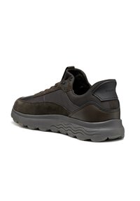 Zapatillas deportivas marrón oscuro con parte superior de ante y material sintético, cuello acolchado, diseño con cordones y suela de goma texturizada con patrón de ondas.