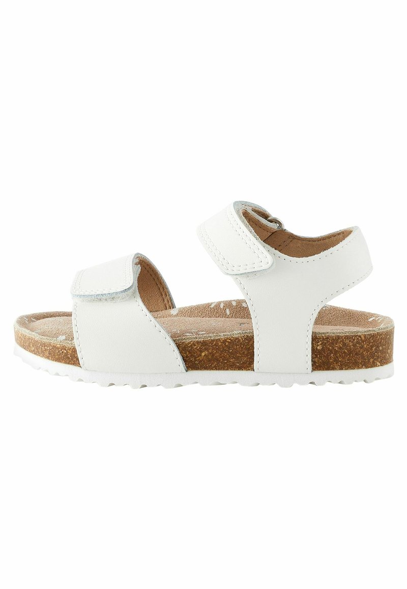 Sandalo bianco con cinturini in velcro regolabili, suola in sughero e soletta testurizzata. Presenta un design piatto e una suola in gomma resistente per una buona aderenza.