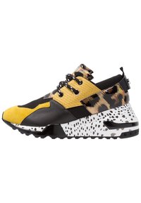 Sportssko med en kombination af sort læder, gule teksturerede paneler og leopardmønstrede detaljer på en hvid spraglet sål.