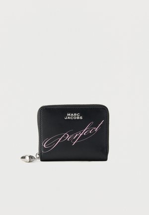 Crni Marc Jacobs novčanik sa srebrnim patentnim zatvaračem i ružičastim kurzivnim tekstom "Perfect" sprijeda na jednobojnoj pozadini.