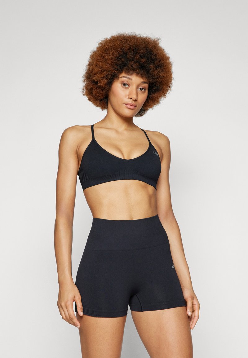 Ensemble de soutien-gorge de sport noir et de shorts taille haute, fabriqué à partir d'un tissu doux et extensible avec une texture lisse et un design minimaliste.