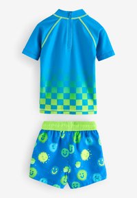 To-delt badetøjssæt med en kortærmet top i lys blå med grønt ternet mønster og matchende blå shorts med smiley-print.