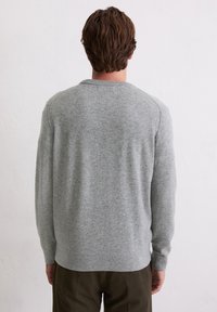 Jasnoszary sweter dziany z okrągłym dekoltem, posiadający długie rękawy i ściągacze. Tylny widok ukazuje bezszwowy design i miękką teksturę.