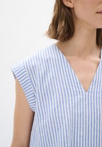 Modrá a biela pruhovaná bezrukávová blúzka s výstrihom do V, s voľným strihom a mäkkou, textúrovanou tkaninou.