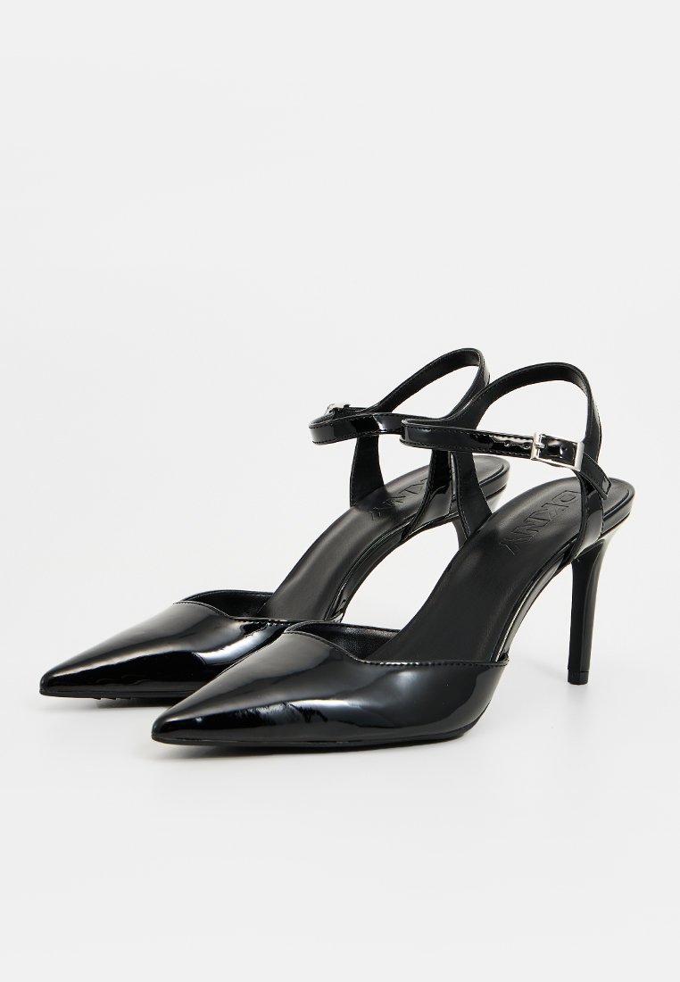 Scarpe con tacco alto in pelle verniciata nera, slingback, con punta affusolata, cinturino alla caviglia regolabile e finitura liscia.