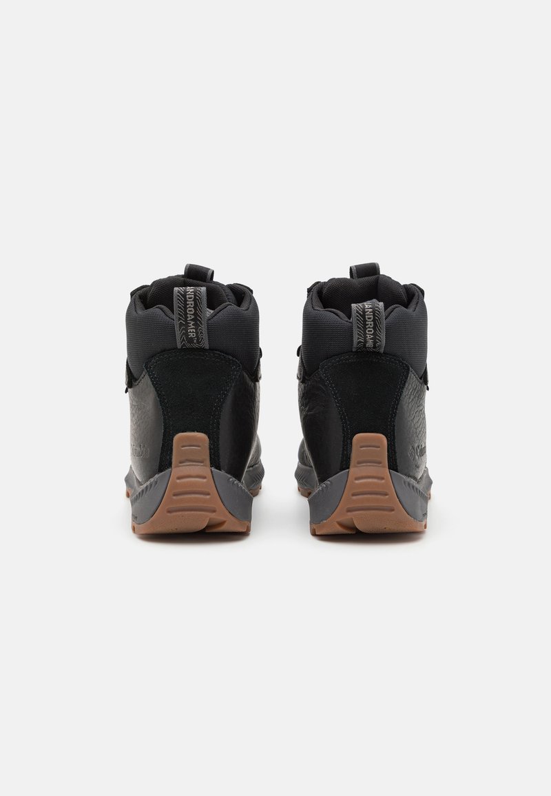 Zapatos de senderismo negros con acabado texturizado, que cuentan con un diseño de tobillo alto, suela de goma y tiradores para facilitar su uso.