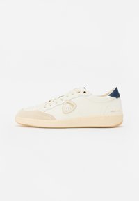 Sneakers albe și bej realizate din materiale din piele și velur, având detalii perforate, ochiuri aurii, un patch cu logo și un accent bleumarin.