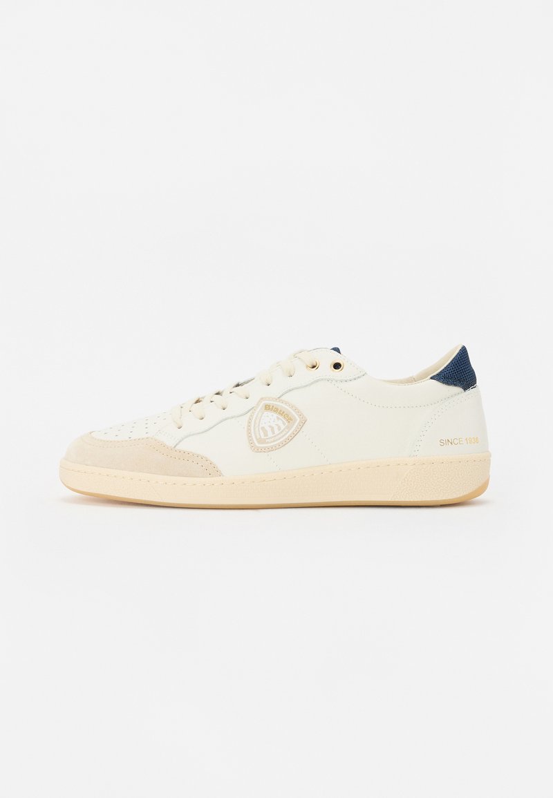 Sneakers albe și bej realizate din materiale din piele și velur, având detalii perforate, ochiuri aurii, un patch cu logo și un accent bleumarin.