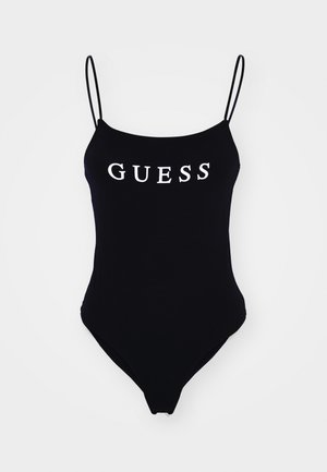 Black one-piece swimsuit featuring thin shoulder straps and a front "GUESS" logo in white. Soft, stretchy fabric with a high-cut leg design.