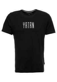 Černé tričko s krátkým rukávem s bílým textem "YRTRN" umístěným na hrudi a kulatým výstřihem.