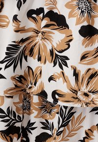 Floral fabric featuring large brown and black flowers on a white background. The material appears soft with a slightly textured finish.
