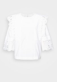 Chemisier blanc avec une finition en œillet texturé sur les manches et le col, comportant des manches courtes bouffantes et une coupe droite.