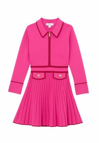 Točasto ružičasta haljina s ovratnikom, prednjim patentnim zatvaračem, dugim rukavima, plisiranim suknjom i dvije preklopne džepne zakrpe sa zlatnim gumbima. Naglašeni kontrastni obrubi.