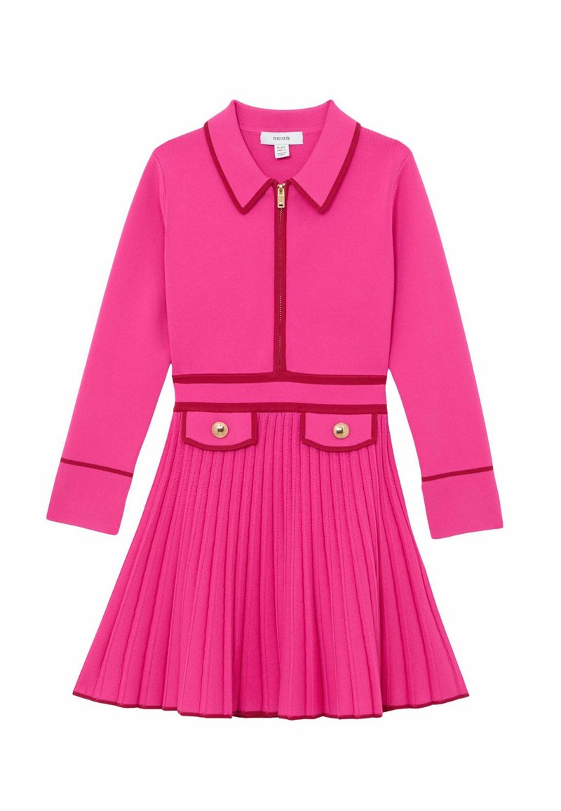 Točasto ružičasta haljina s ovratnikom, prednjim patentnim zatvaračem, dugim rukavima, plisiranim suknjom i dvije preklopne džepne zakrpe sa zlatnim gumbima. Naglašeni kontrastni obrubi.