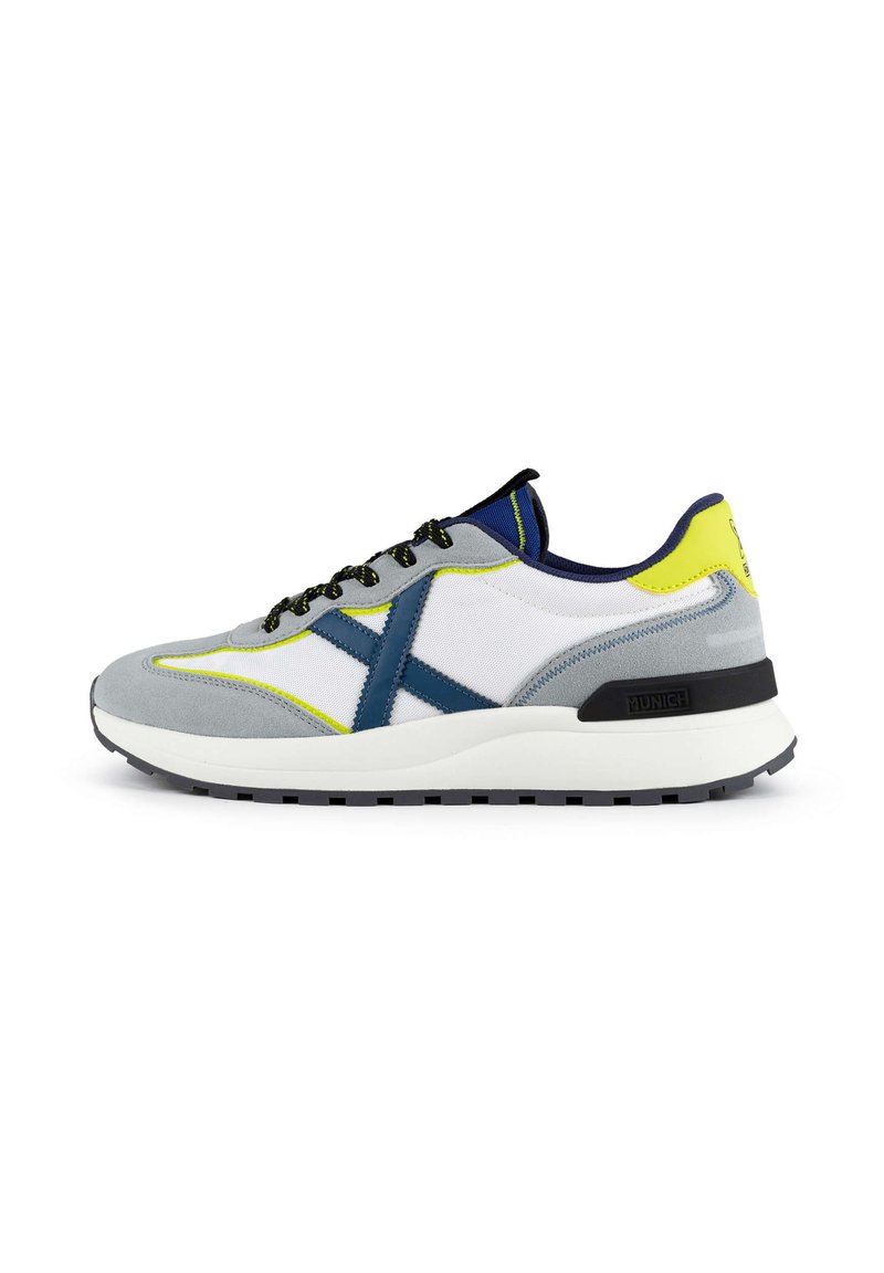 Baskets pour hommes, en daim gris et maille blanche, avec des accents bleus, des touches jaunes, des lacets noirs et une semelle en caoutchouc texturé.