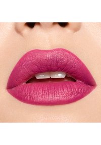 Rouge à lèvres mat rose sur des lèvres pleines, présentant une texture lisse avec des lignes subtiles et une finition uniforme. Le fond neutre met en valeur les couleurs.