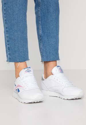 Sneakers atletiche bianche con design in pelle testurizzata, caratterizzate da accenti rosa e blu, punta rotonda e collo imbottito. Suola in gomma.