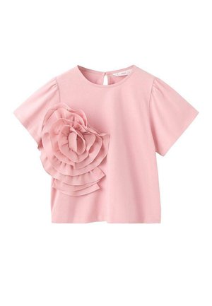 Haut rose à manches courtes en tissu doux, avec un grand détail en forme de fleur froufroutante sur le côté gauche et un col rond avec une ouverture en trou de serrure à l'arrière.