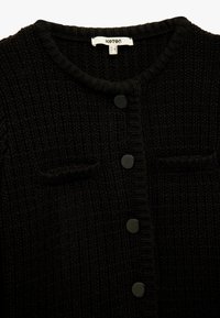 Schwarze Strickjacke mit einem strukturierten Muster, rundem Halsausschnitt und drei Knöpfen auf der Vorderseite, mit zwei kleinen Taschen.