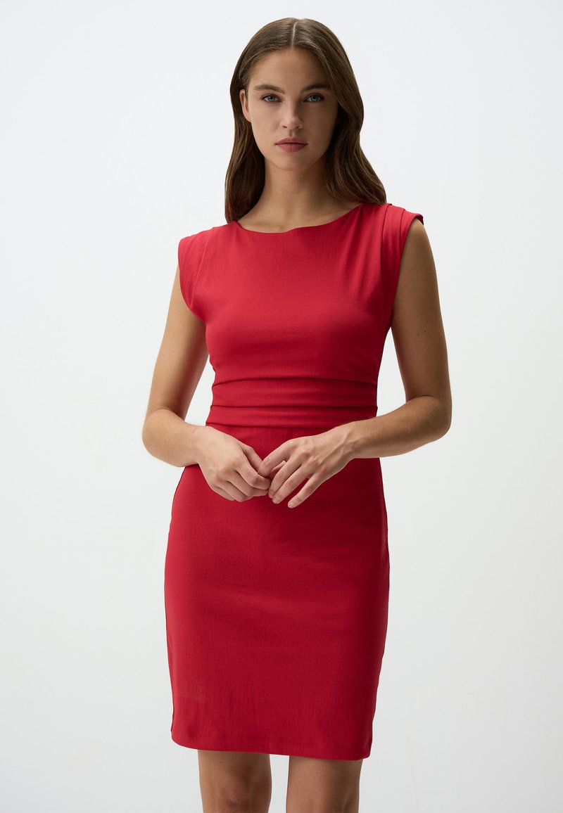 Abito rosso aderente con maniche a capo, texture liscia, lunghezza al ginocchio. Il design include una vita strutturata e un collo rotondo.